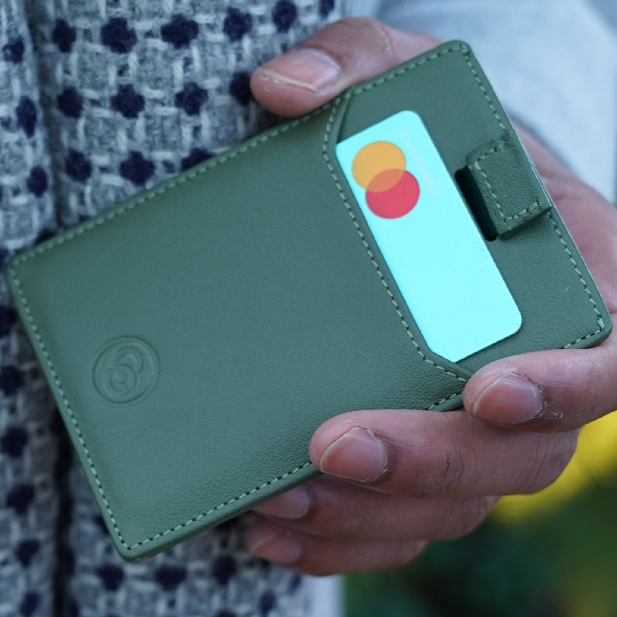 slim green wallet with card slots and cash section held in hand